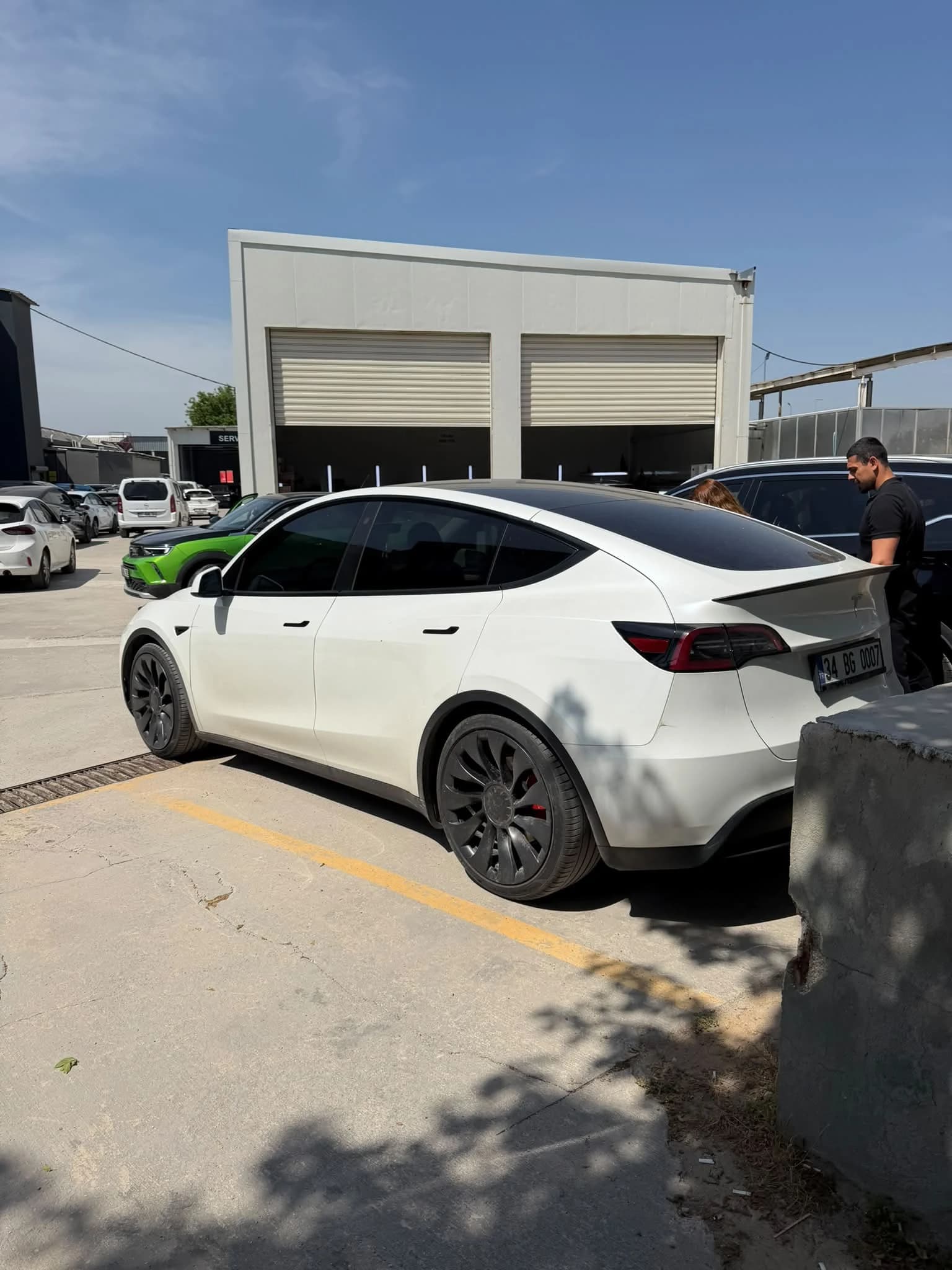 Otoparkta arkadan üç çeyrek açıyla çekilmiş beyaz Tesla